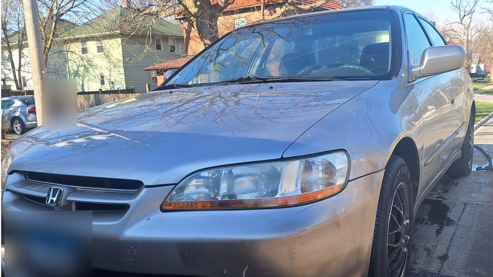 Silver Honda Accord sedan parked beside a flatbed tow truck